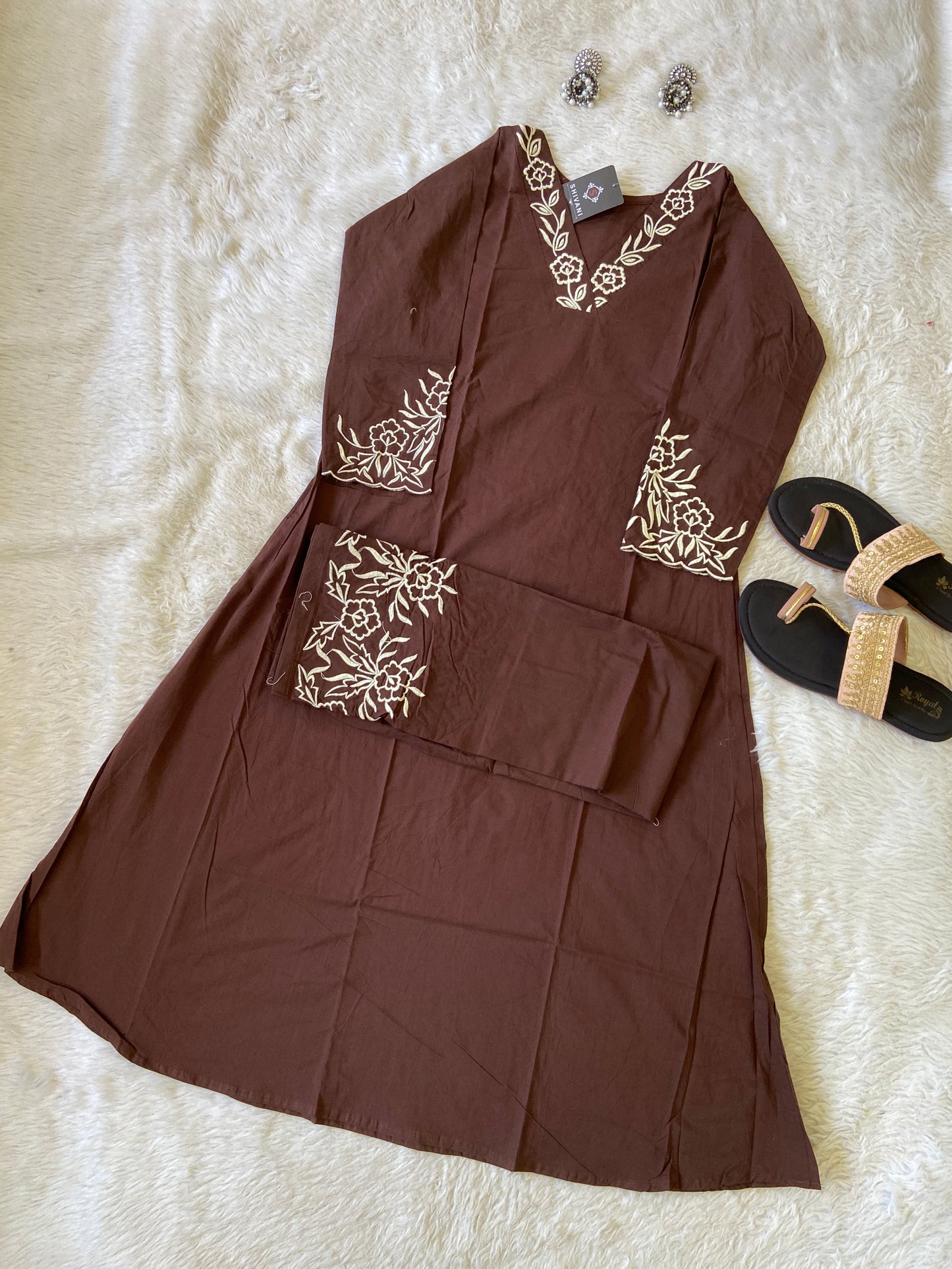 Brown fabric with floral embroidery on a white surface