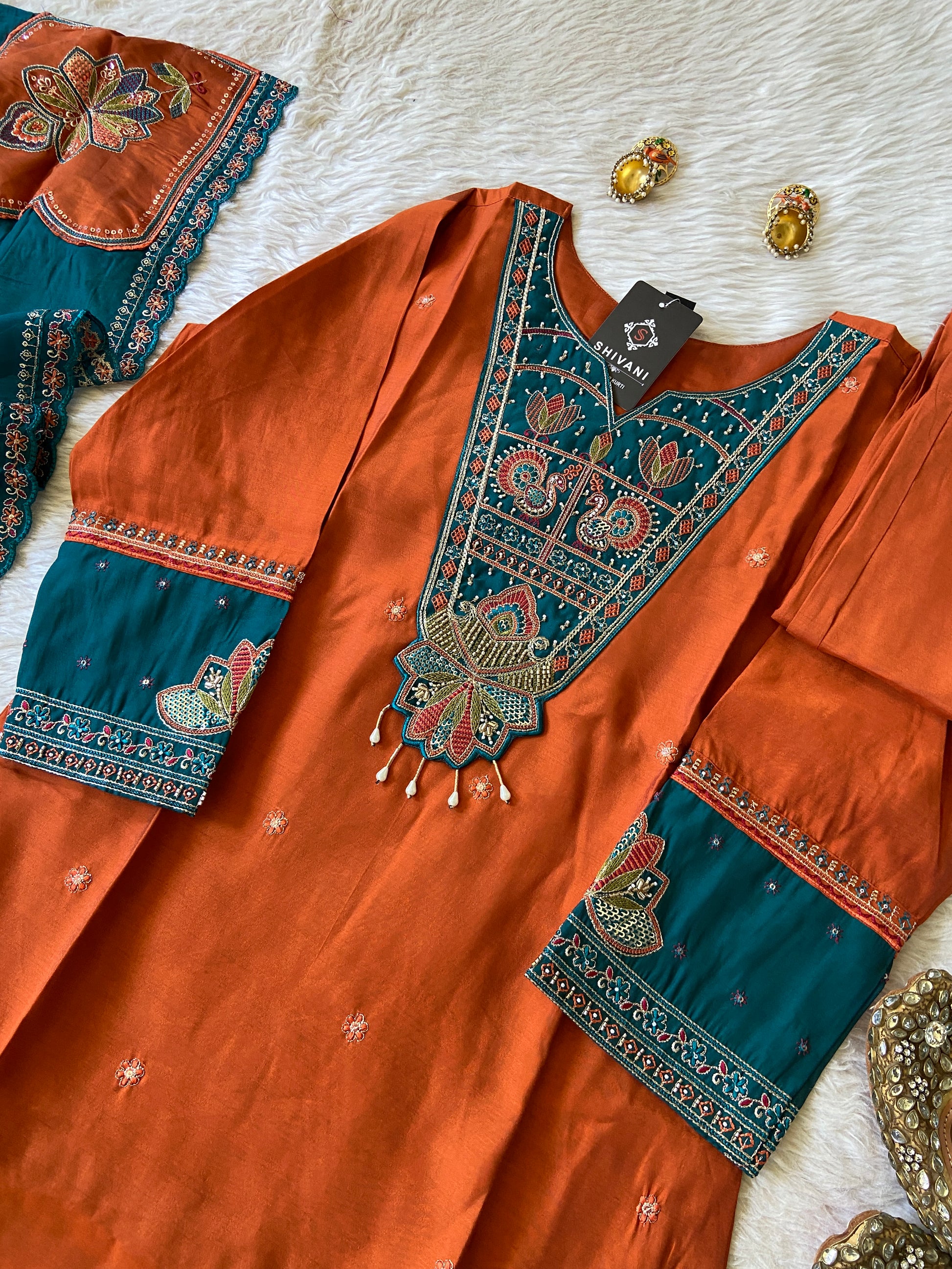Orange and blue embroidered fabric on a white surface
