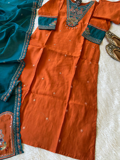 Orange and blue traditional outfit with intricate patterns on a white surface