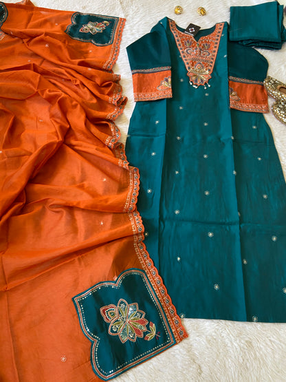 Teal and orange traditional outfit with intricate patterns on a textured surface