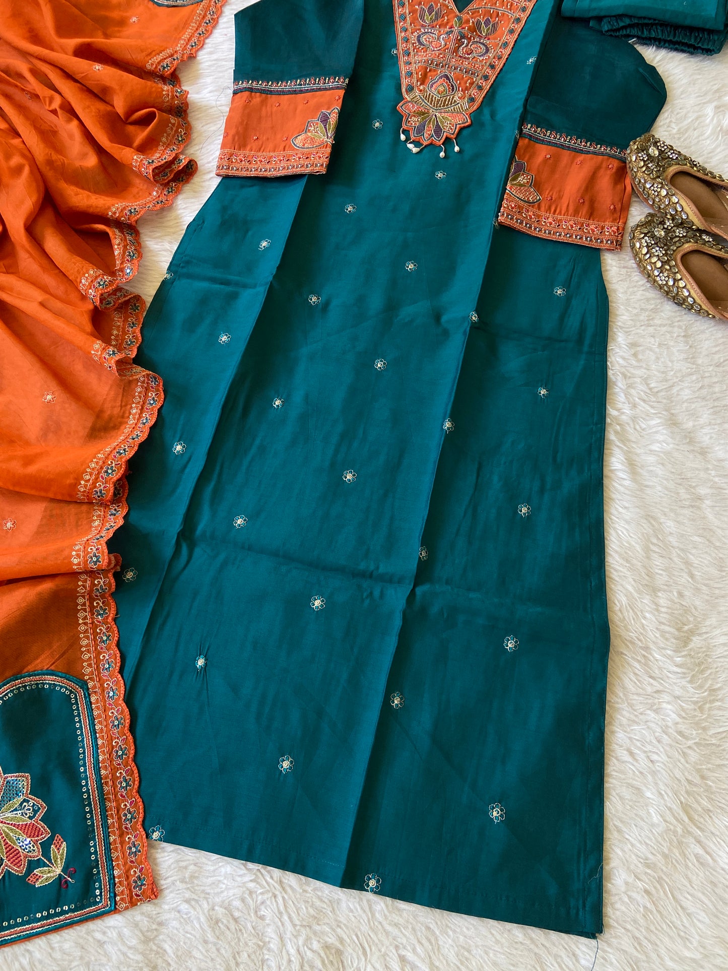 Traditional blue and orange saree with intricate patterns on a white surface