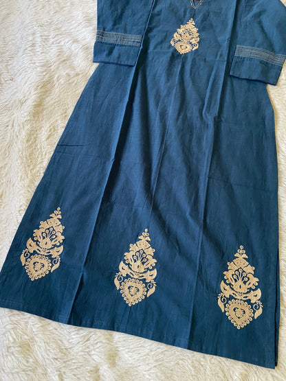 Blue fabric with gold embroidery on a textured beige surface