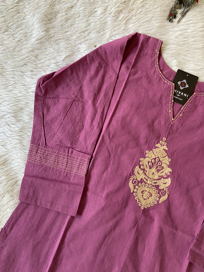 Purple garment with gold embroidery on a white fluffy surface