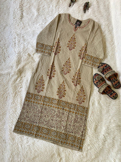 Beige kurta with floral patterns on a white textured surface