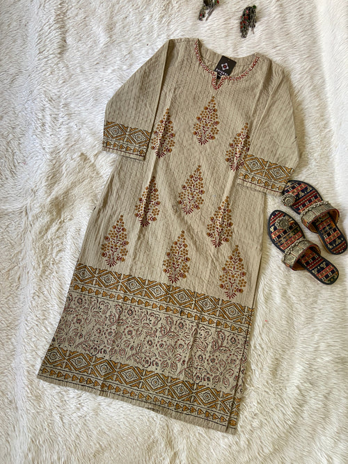 Beige kurta with floral patterns on a white textured surface