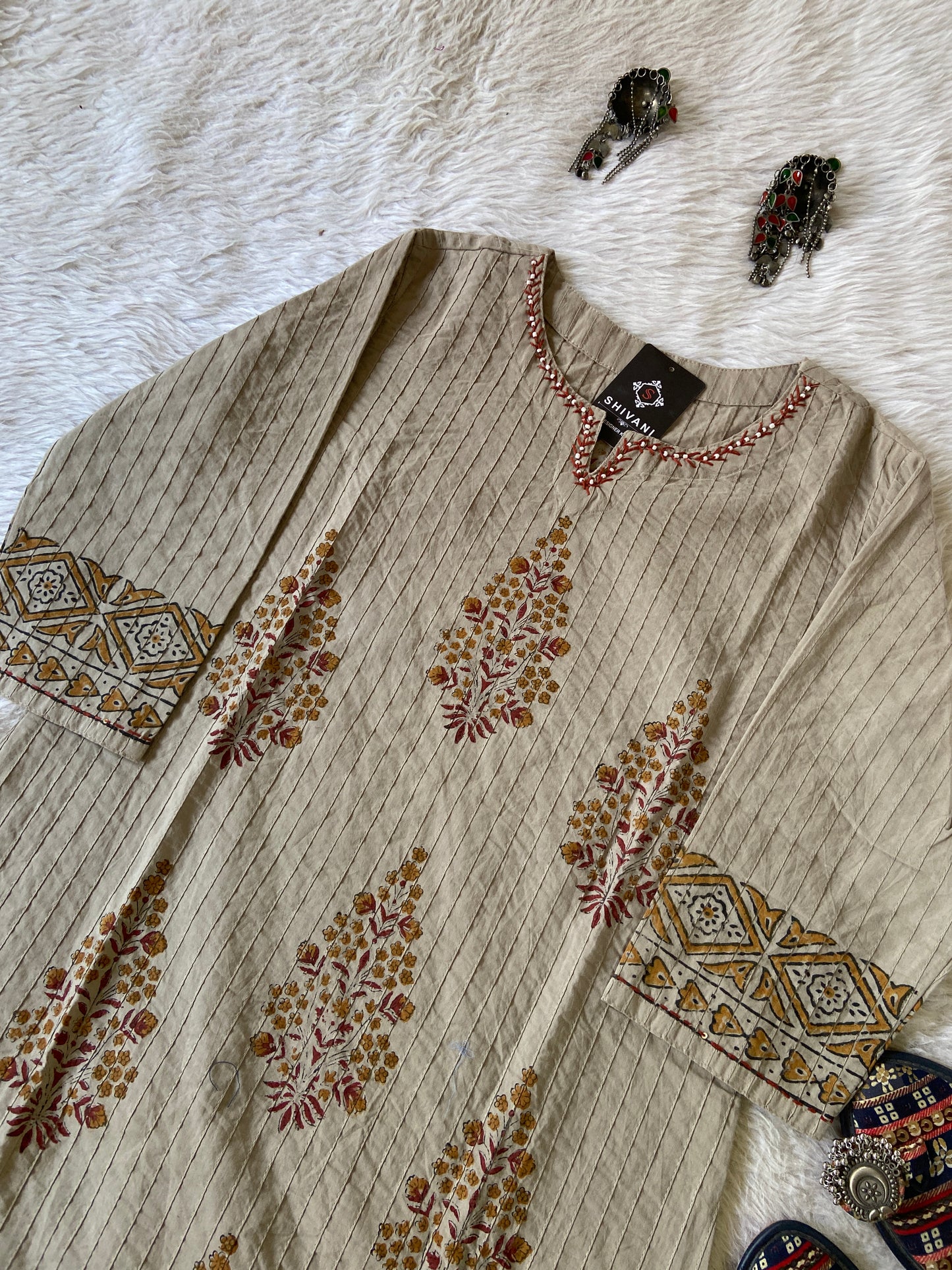 Beige fabric with intricate patterns on a white fur surface