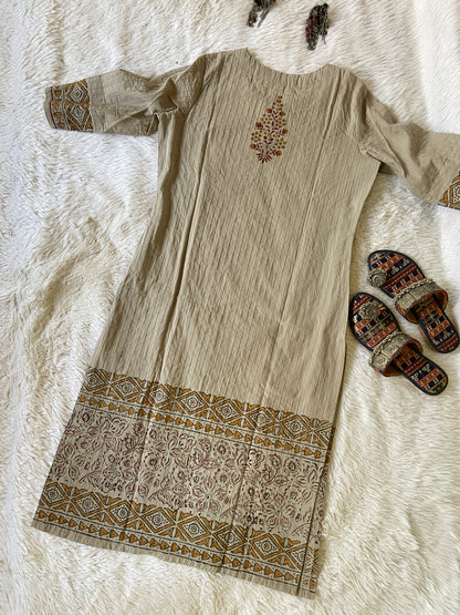 Beige fabric with intricate patterns on a textured surface