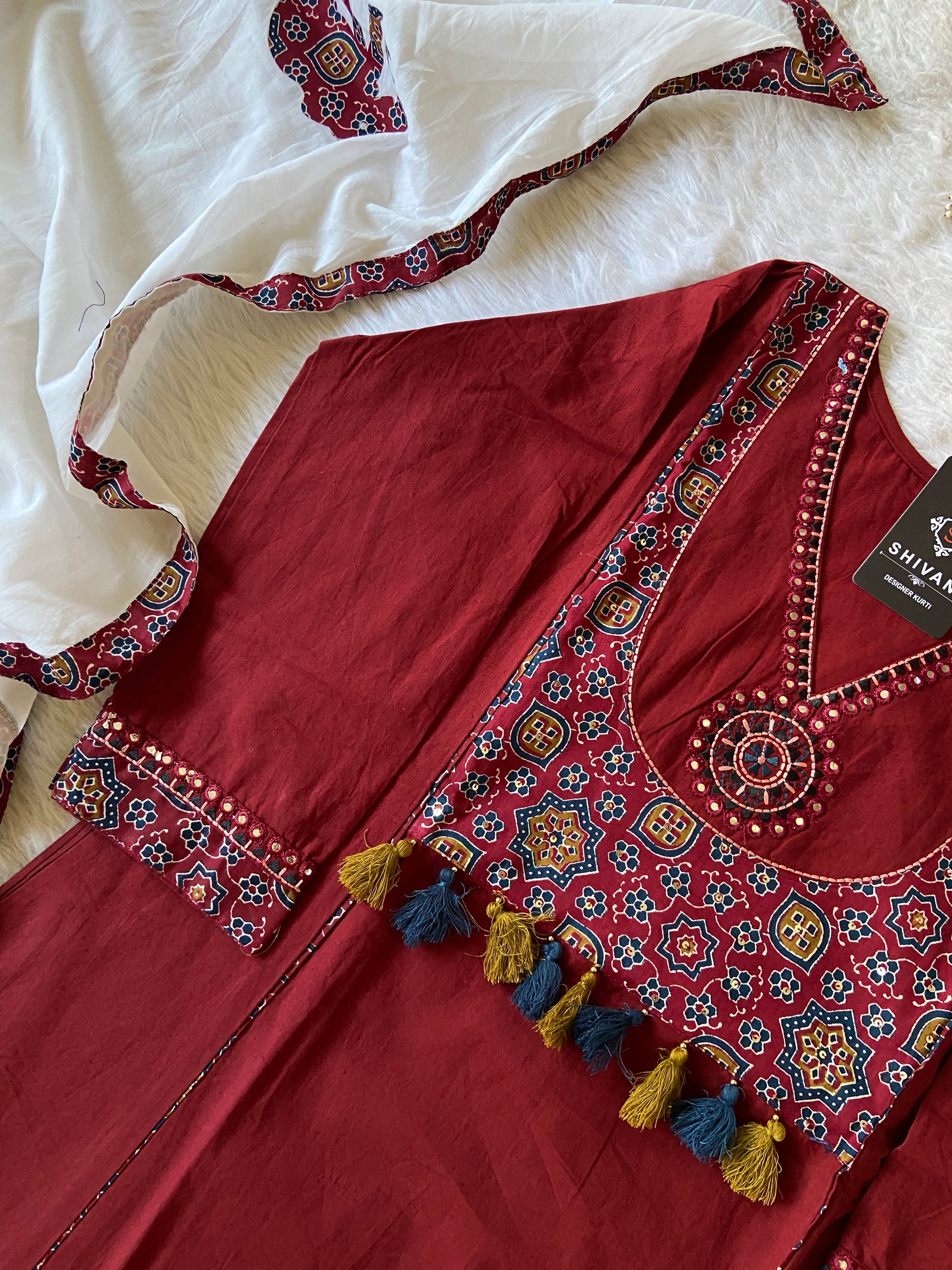Maroon embroidered traditional outfit with white fabric underneath