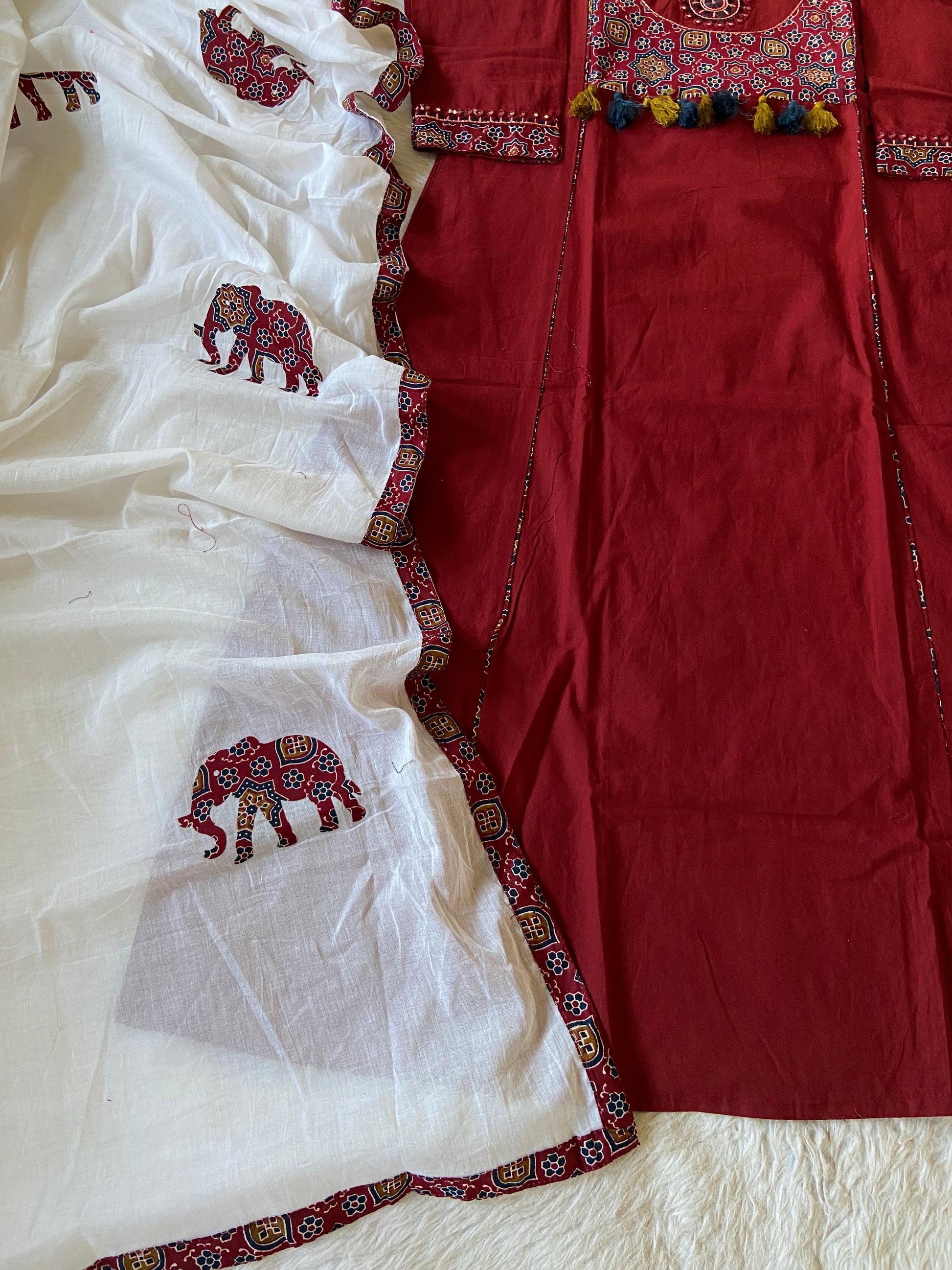 Red and white fabric with embroidered patterns on a textured surface