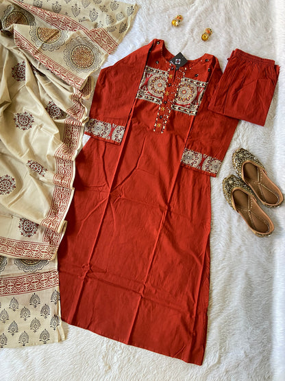 Red traditional outfit with embroidered details on a textured surface