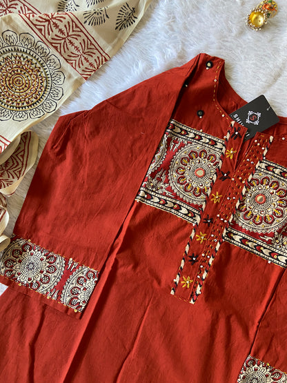 Red fabric with intricate gold patterns on a white surface