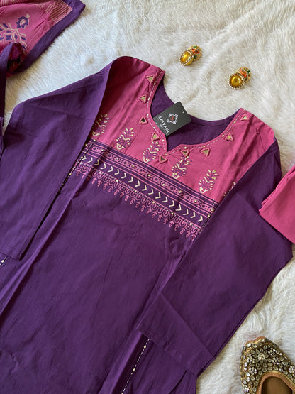 Purple dress with pink embroidery on a white fur surface
