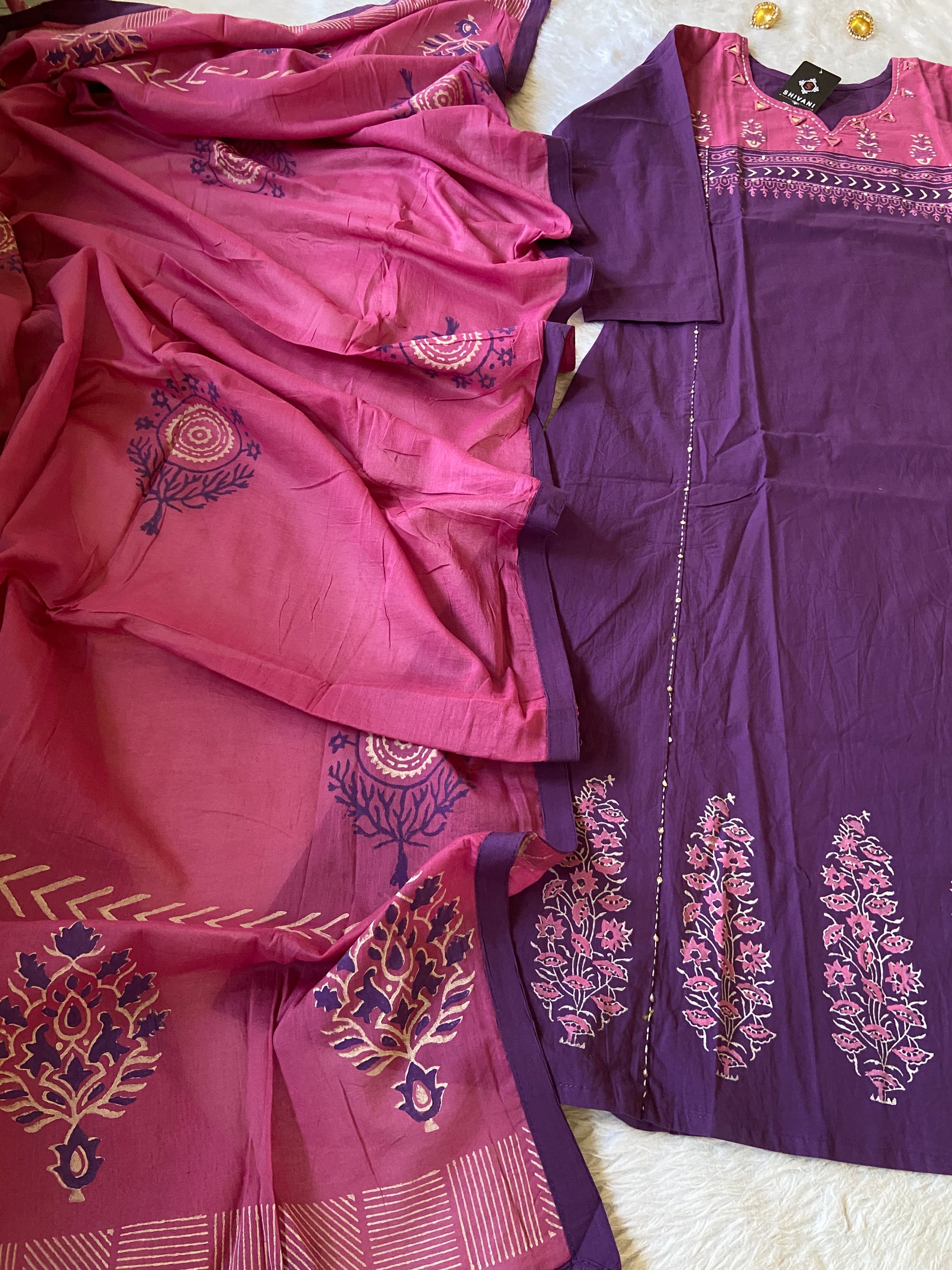 Purple and pink saree with intricate patterns on a white background
