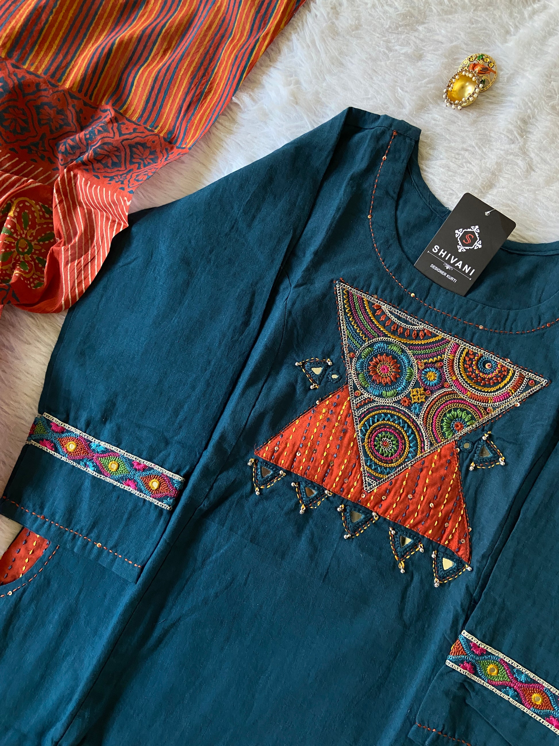 Blue garment with colorful embroidery on a textured surface
