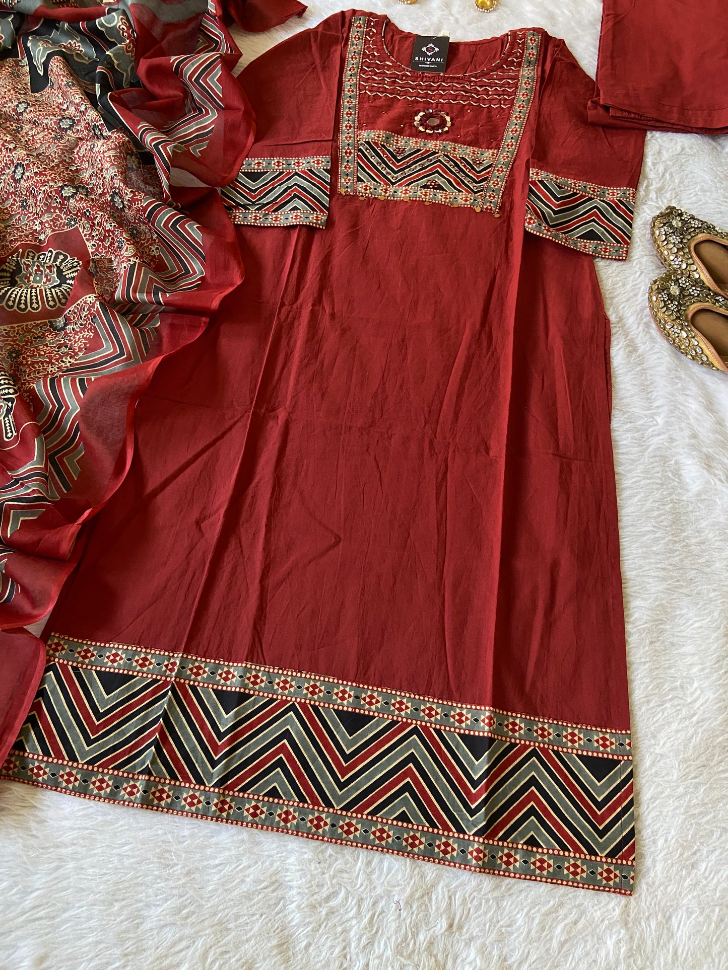 Red traditional outfit with intricate patterns on a white surface