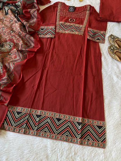 Red traditional outfit with intricate patterns on a white surface