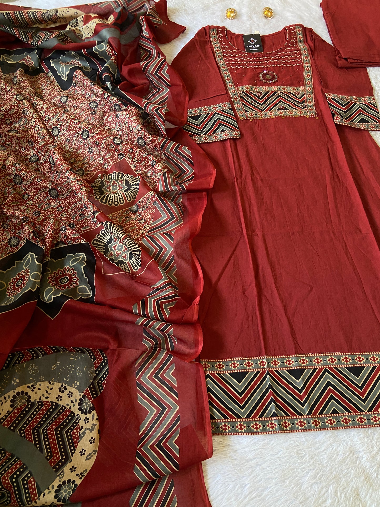 Red traditional outfit with intricate patterns on a white surface