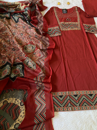 Red traditional outfit with intricate patterns on a white surface