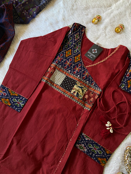 Maroon traditional outfit with intricate patterns on a white surface
