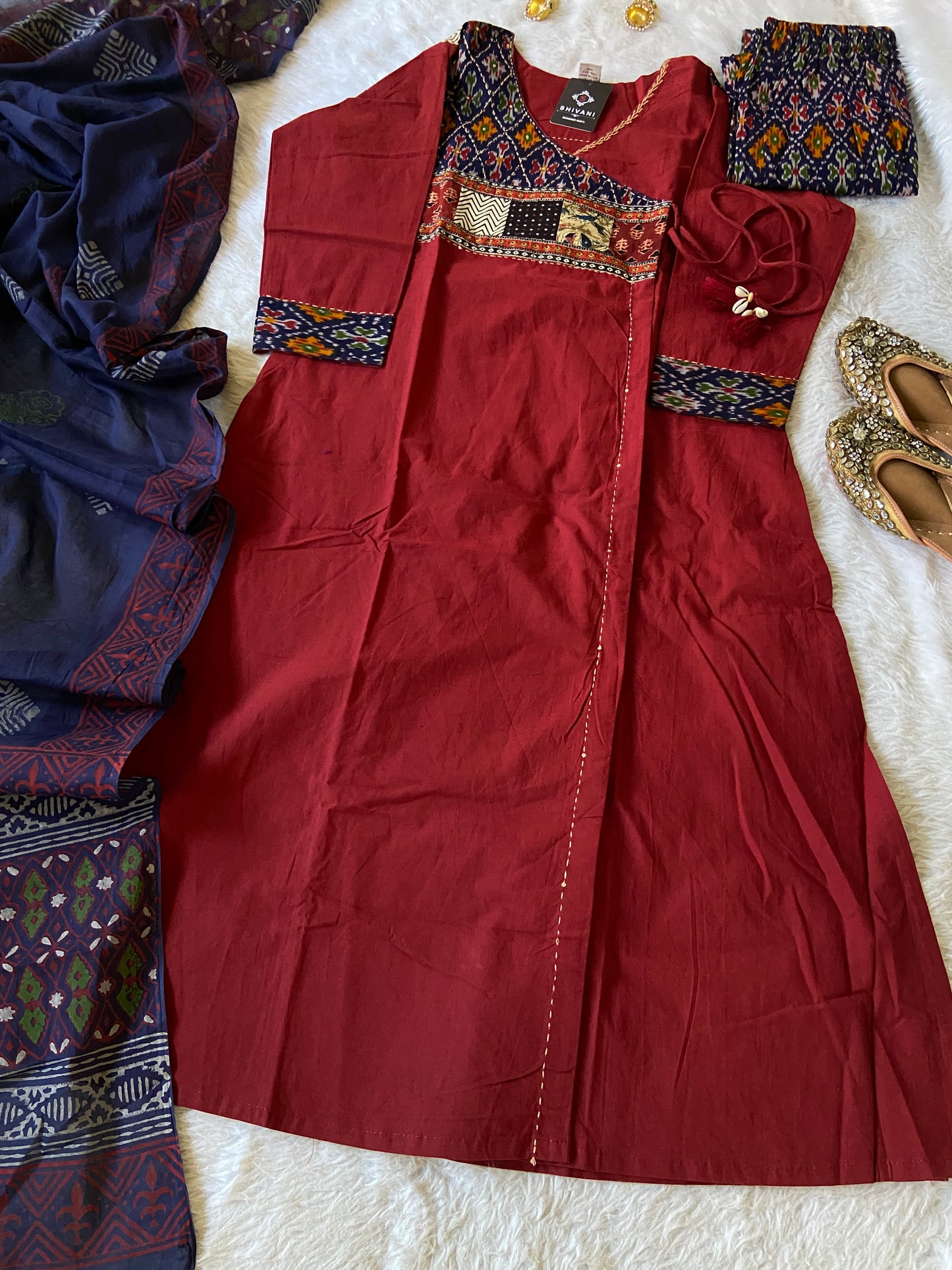 Red traditional outfit with intricate patterns on a white surface