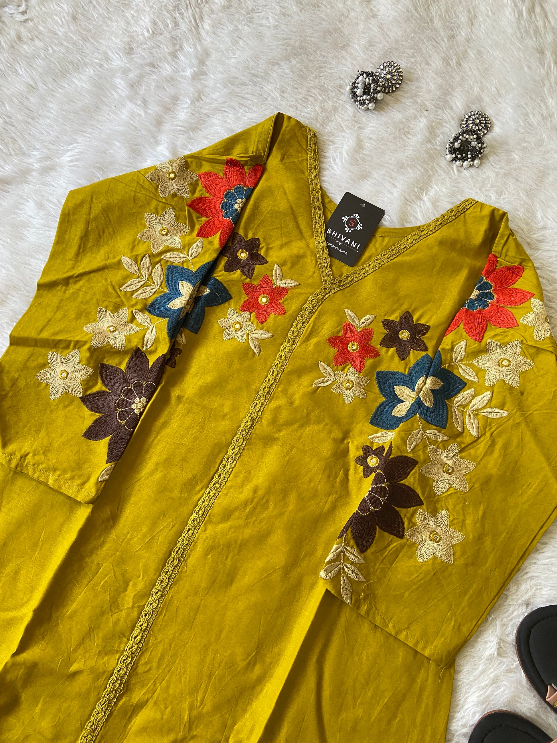 Yellow garment with floral embroidery on a white surface
