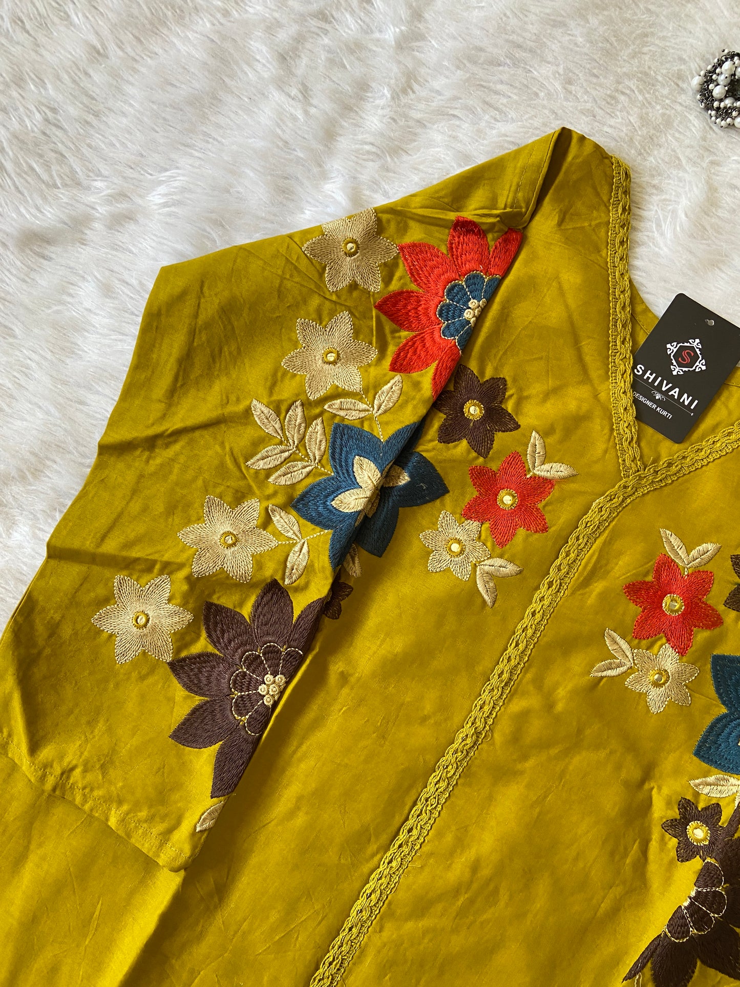 Yellow fabric with floral embroidery on a white fur background