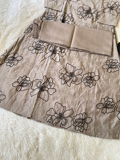 Beige fabric with black floral patterns on a white surface