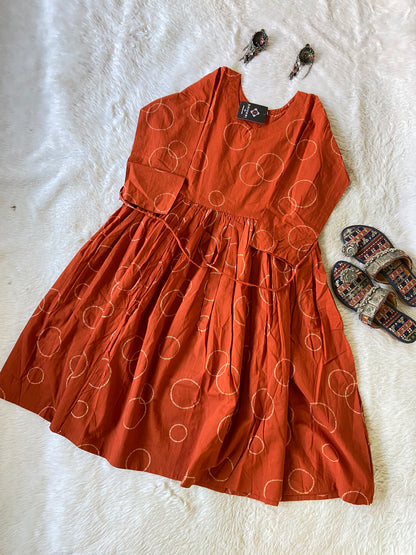 Orange dress with circular pattern on a white surface