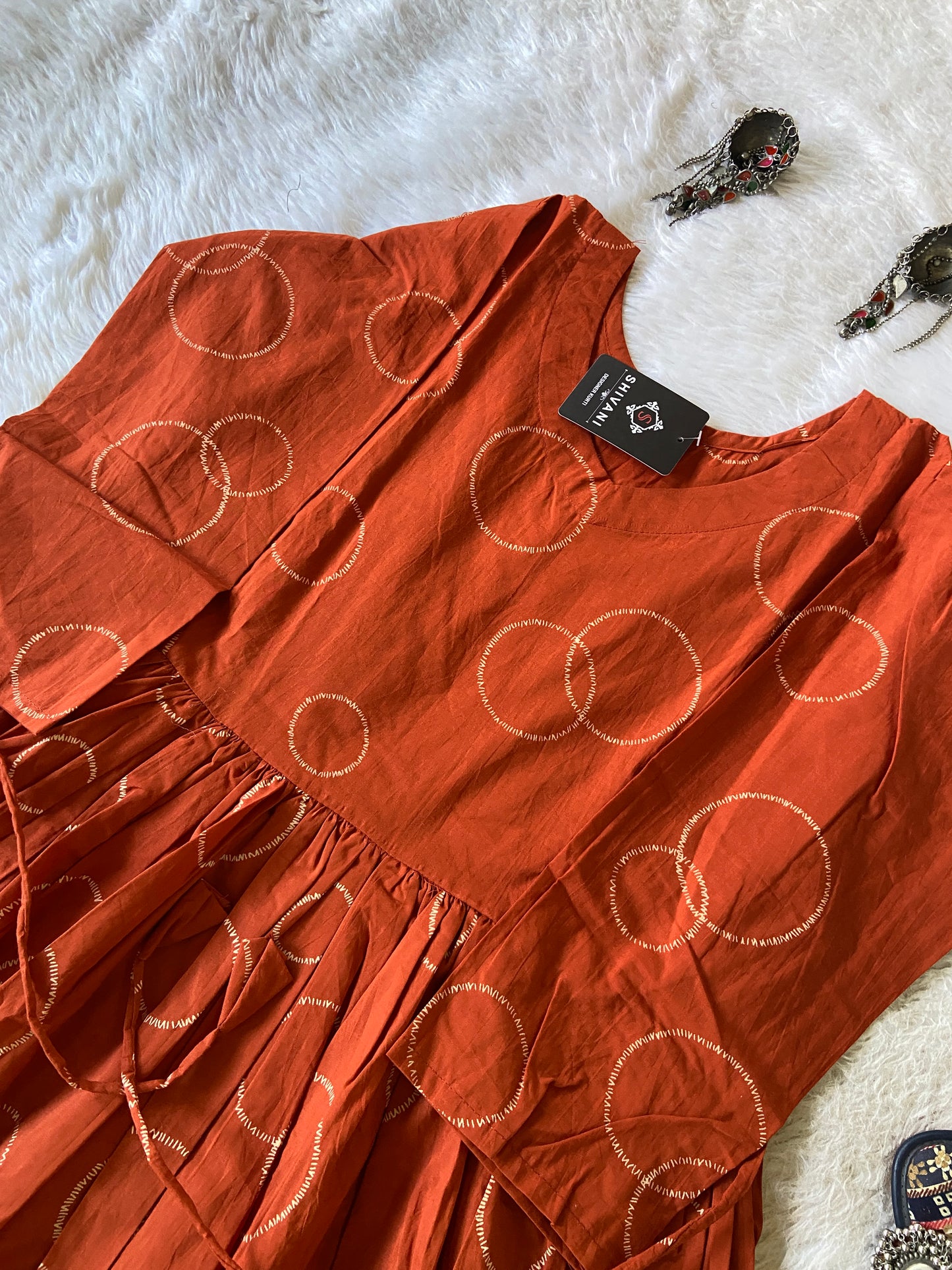 Orange fabric with circular patterns on a white fur surface