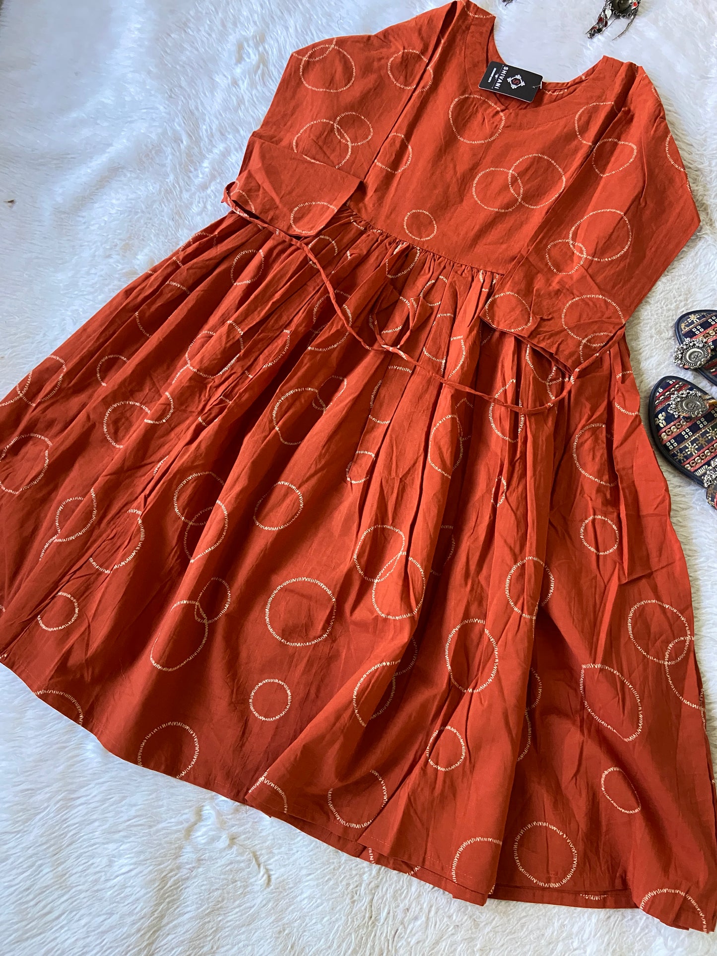 Orange dress with white circle pattern on a white surface