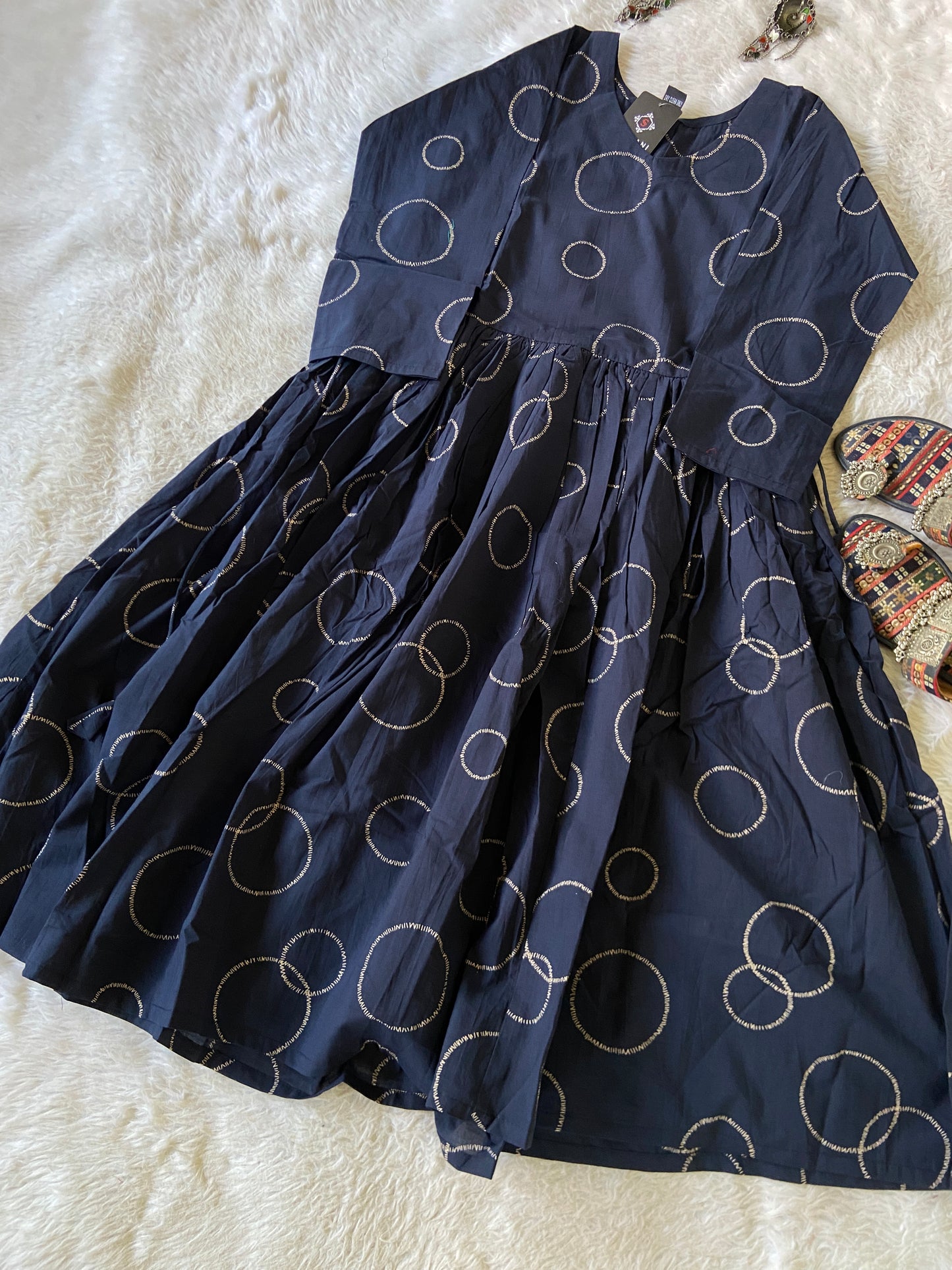 Navy blue fabric with gold circular patterns on a textured white surface