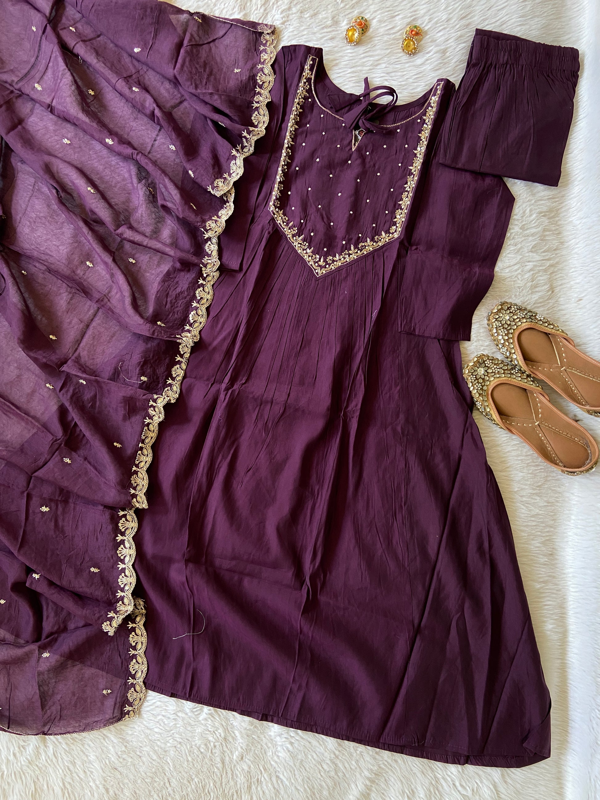 Purple dress with gold embroidery on a white surface