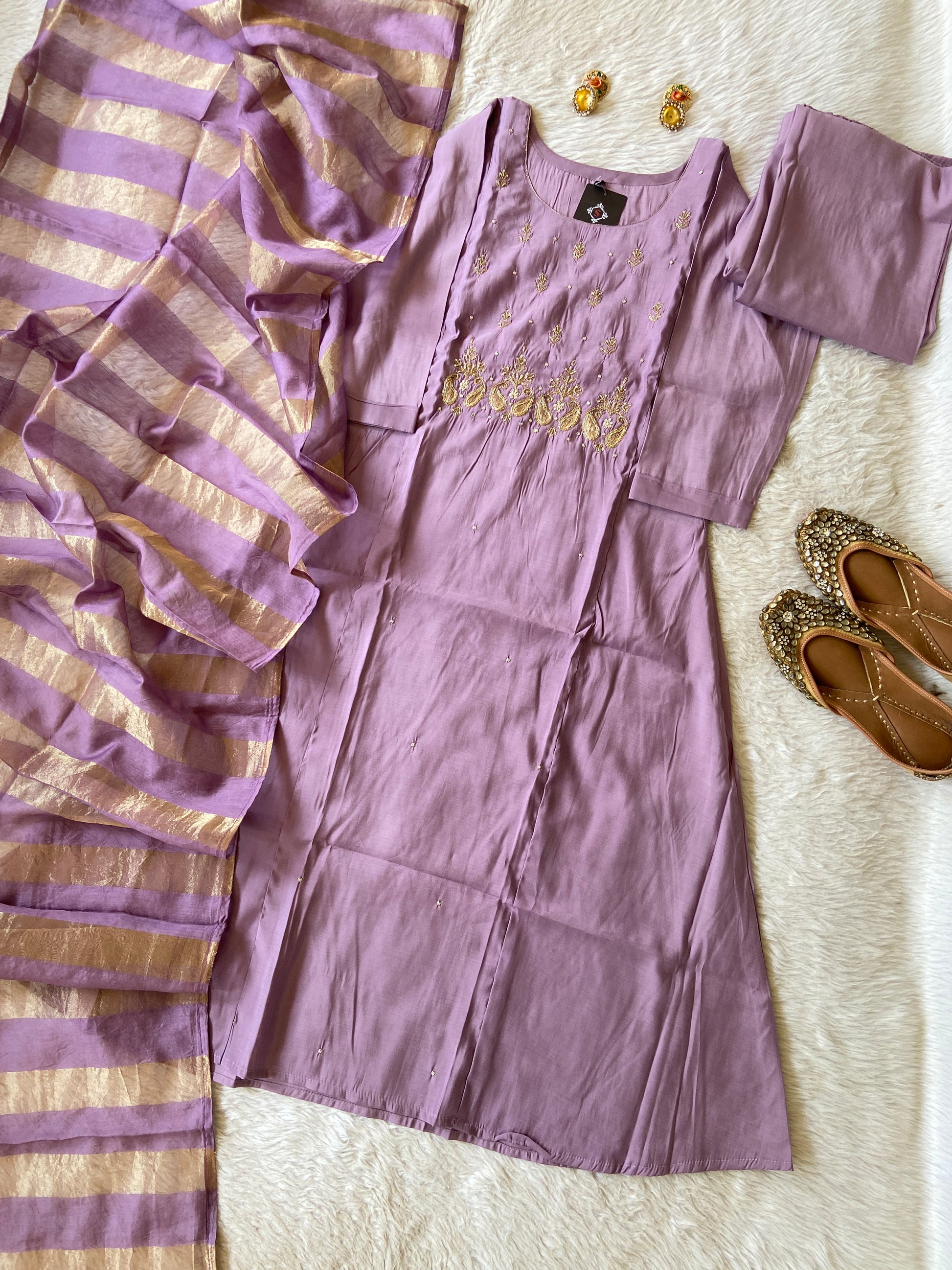 Purple saree with gold stripes on a white surface