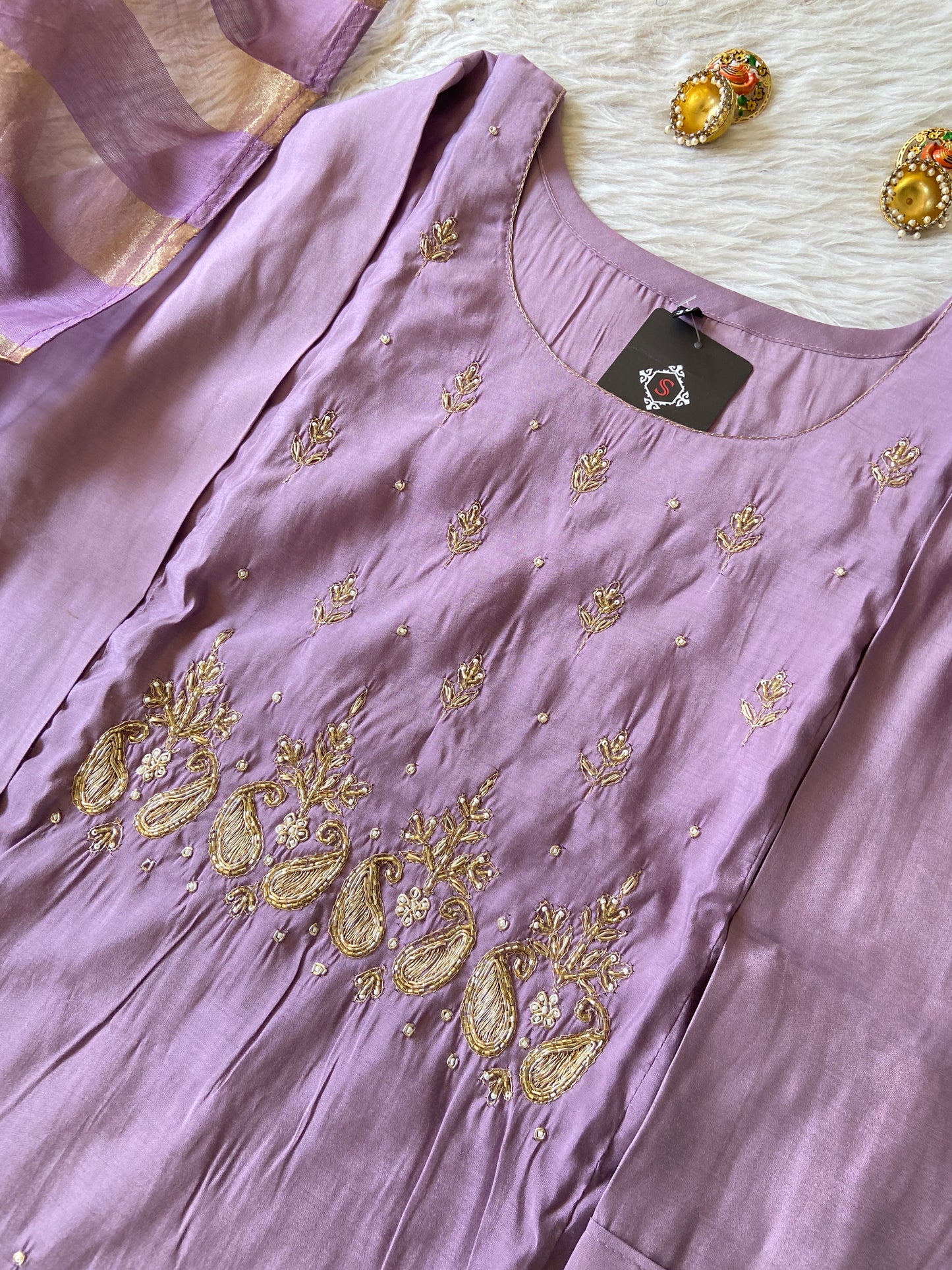 Purple dress with gold embroidery on a white surface
