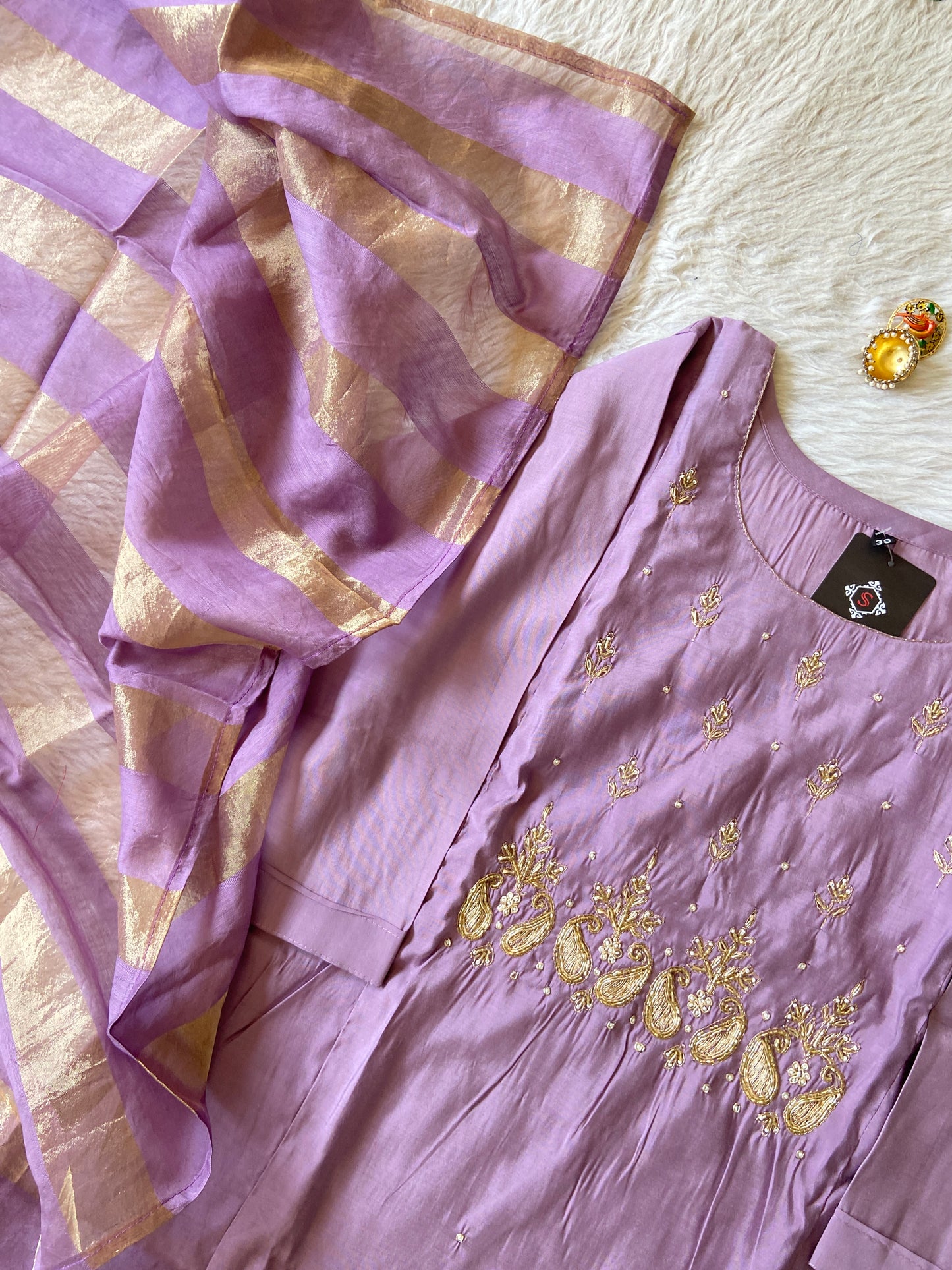 Purple embroidered dress with gold accents on a light background