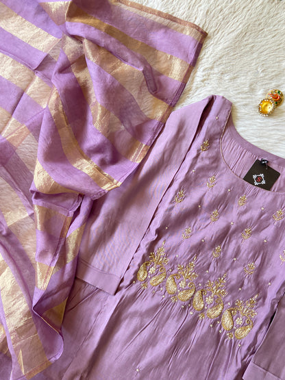 Purple embroidered dress with gold accents on a light background