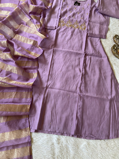 Purple fabric with gold patterns on a textured surface