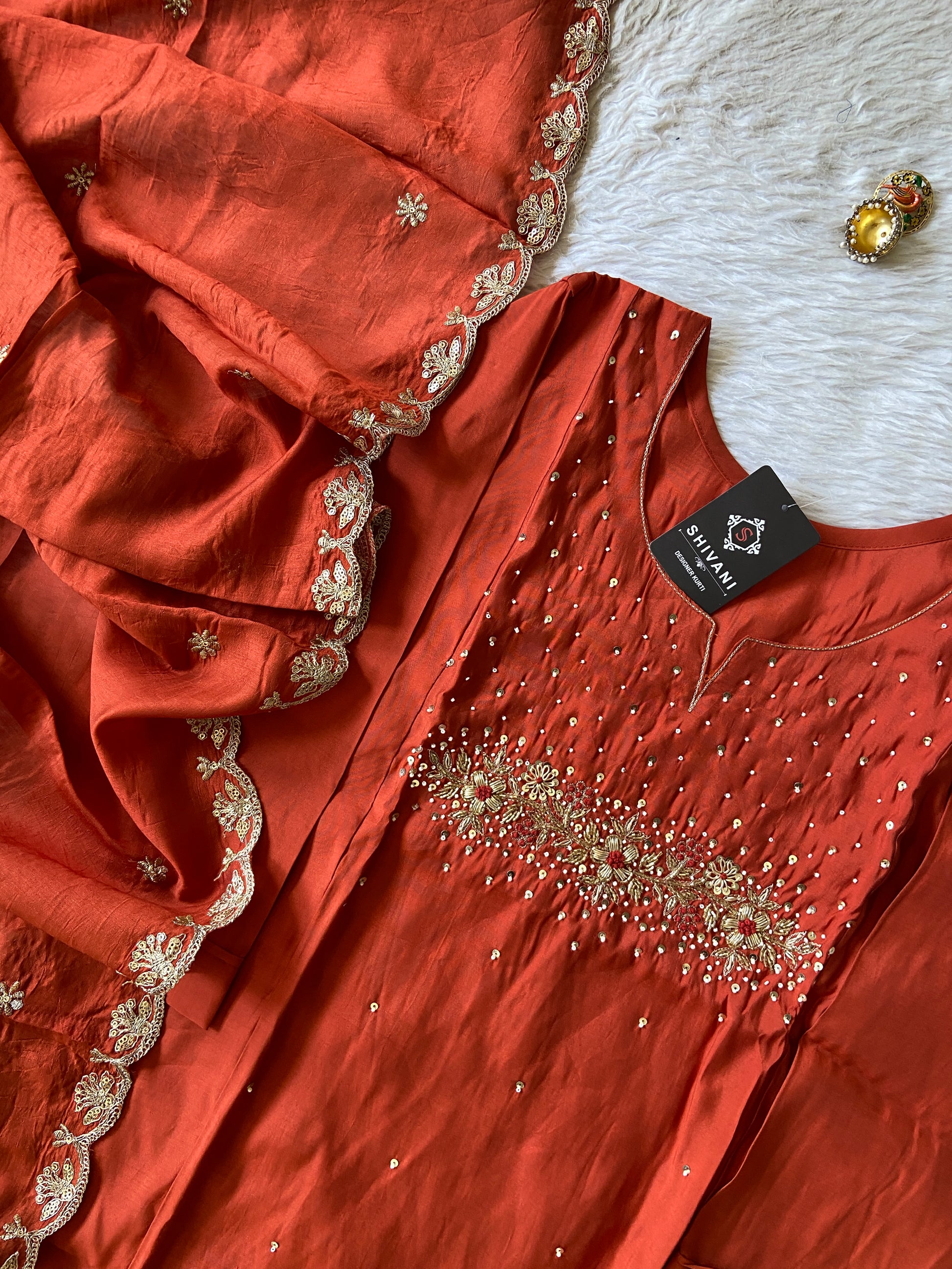 Red embroidered fabric with a tag on a white background
