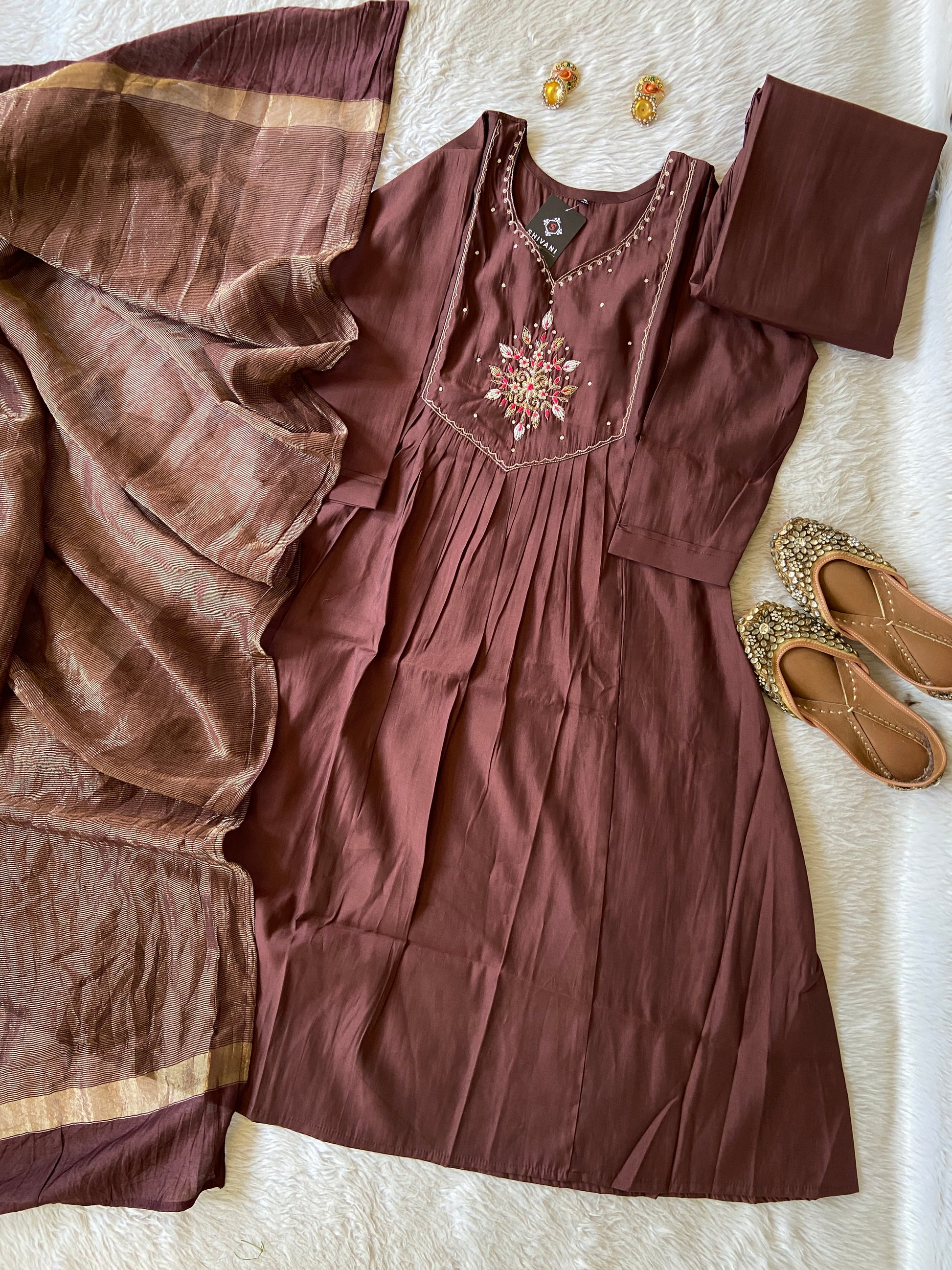 Brown dress with intricate detailing on a white surface