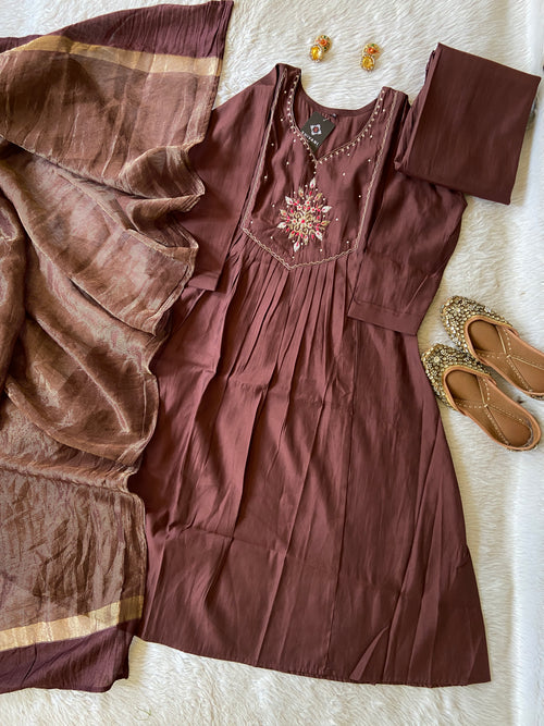 Brown dress with intricate detailing on a white surface