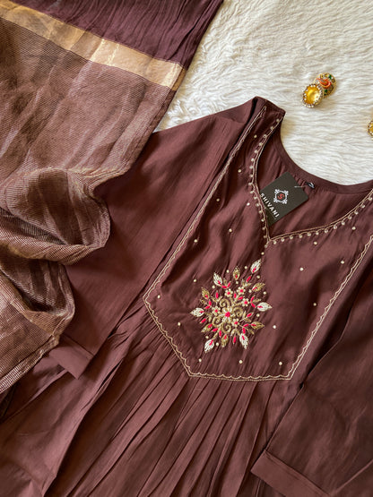 Brown embroidered garment on a white surface