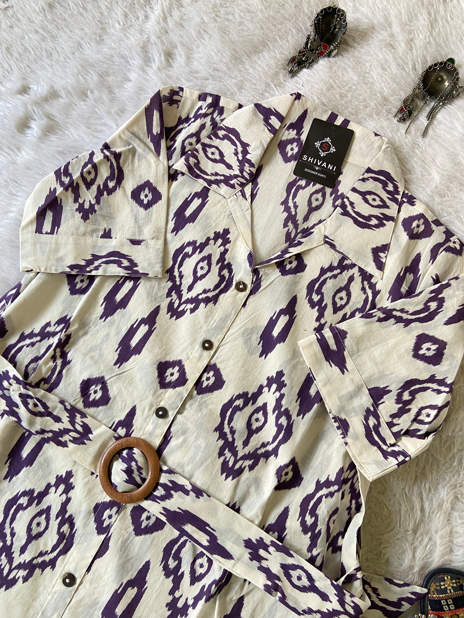 White shirt with purple geometric pattern on a textured surface