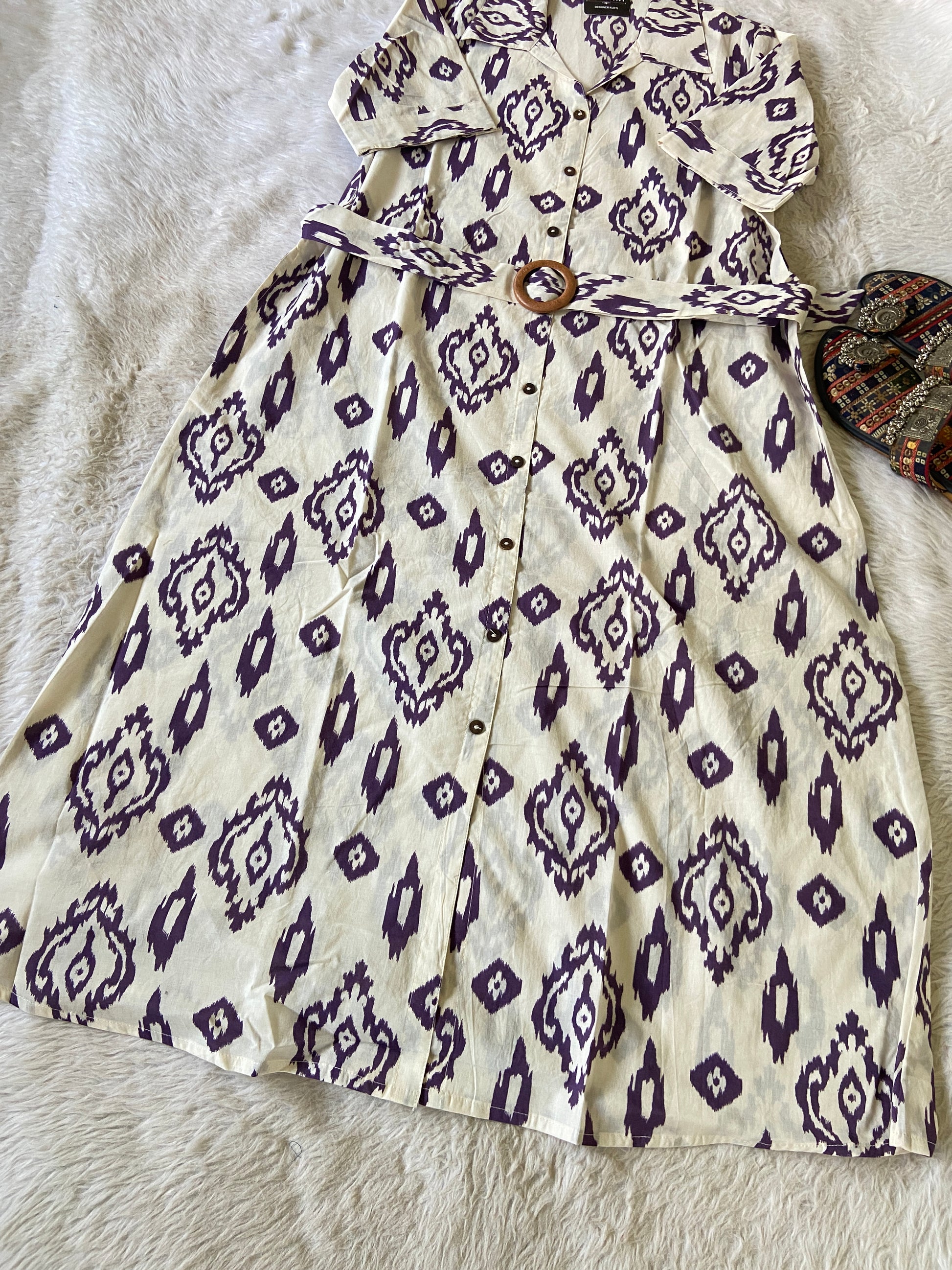 White dress with purple geometric pattern on a textured surface