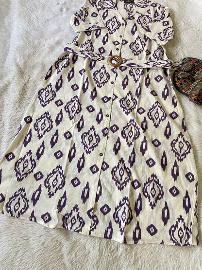 White dress with purple geometric pattern on a textured surface