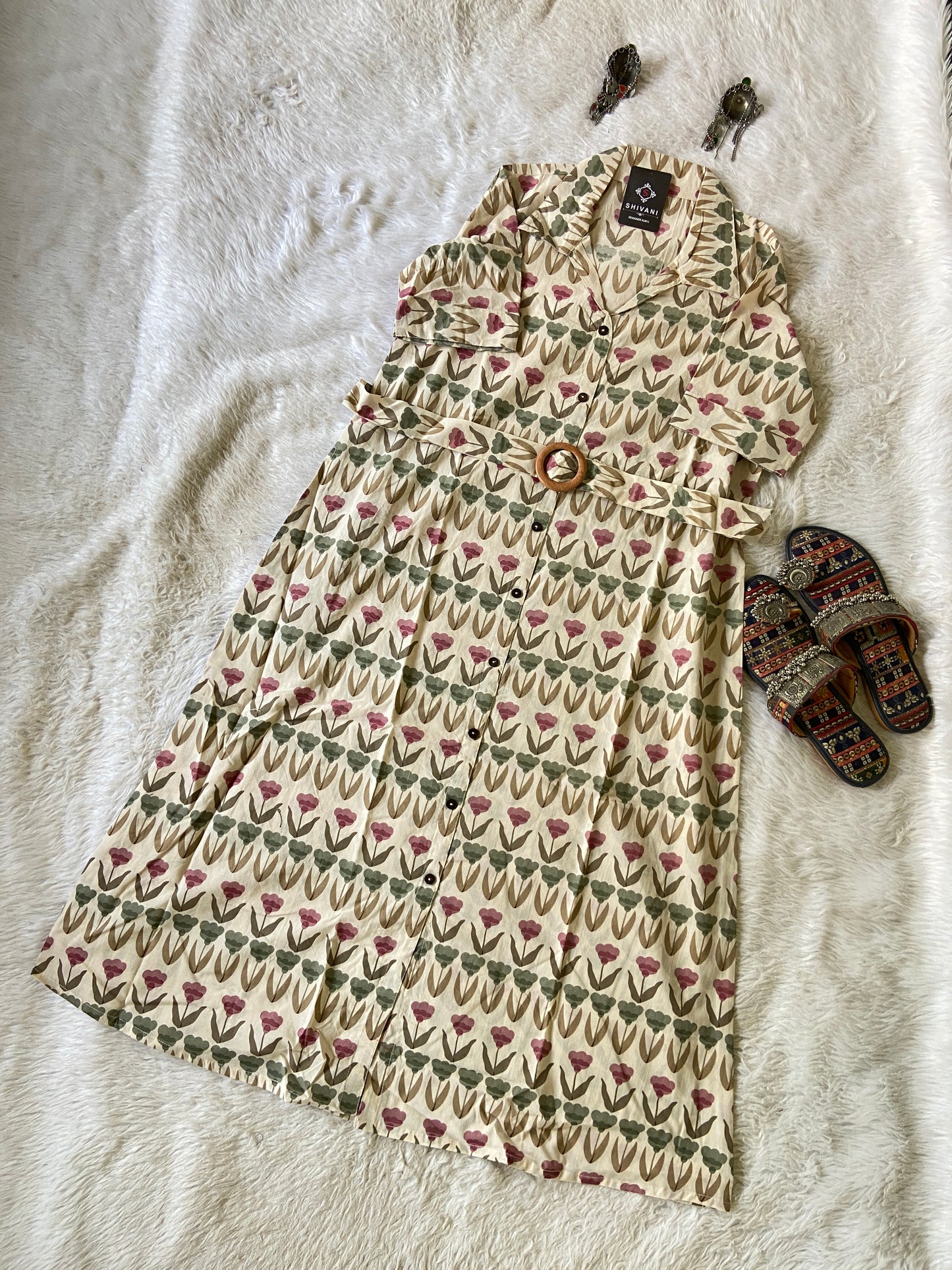 Patterned dress with a pair of slippers on a textured surface