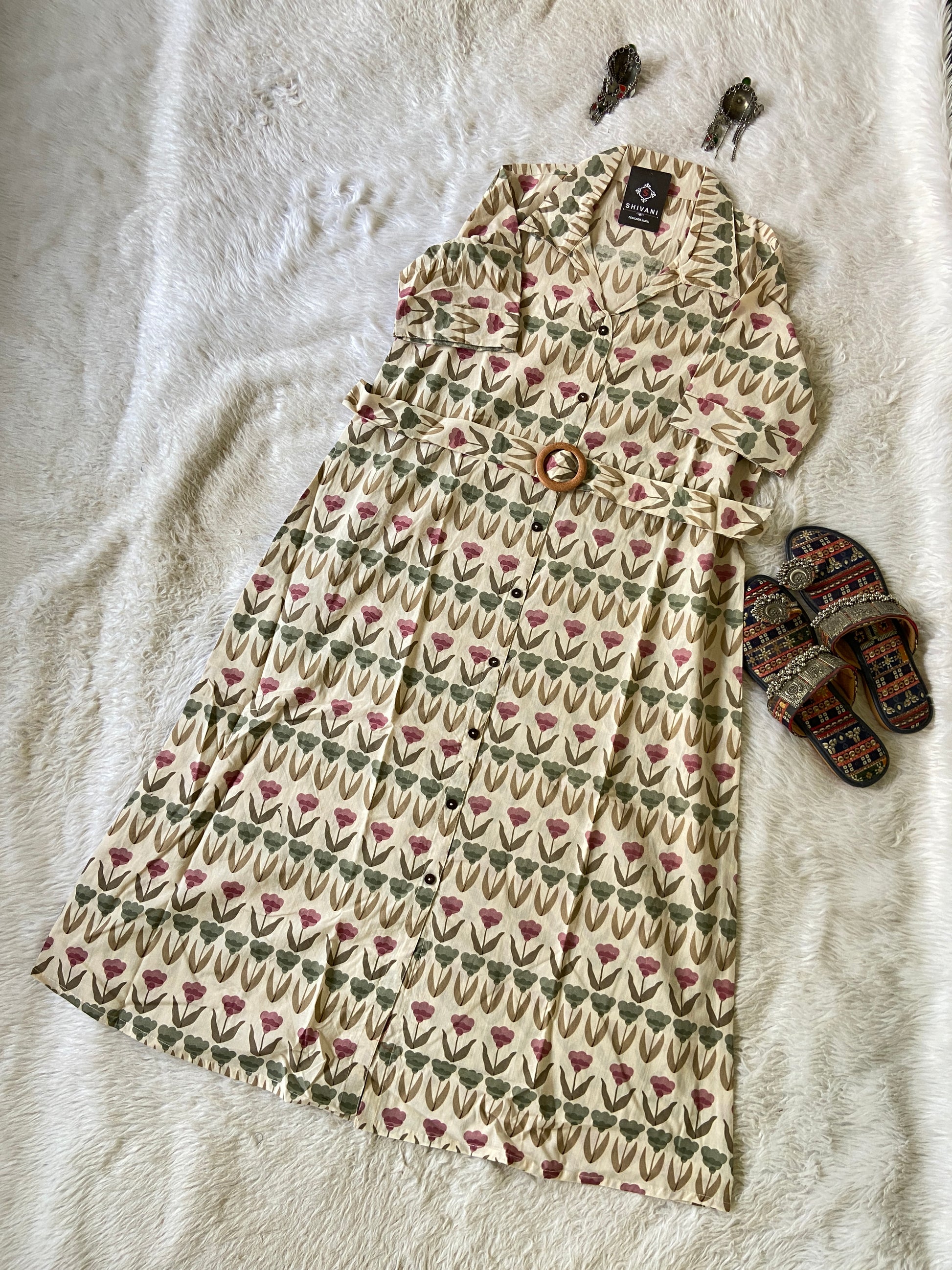 Patterned dress with a pair of slippers on a textured surface