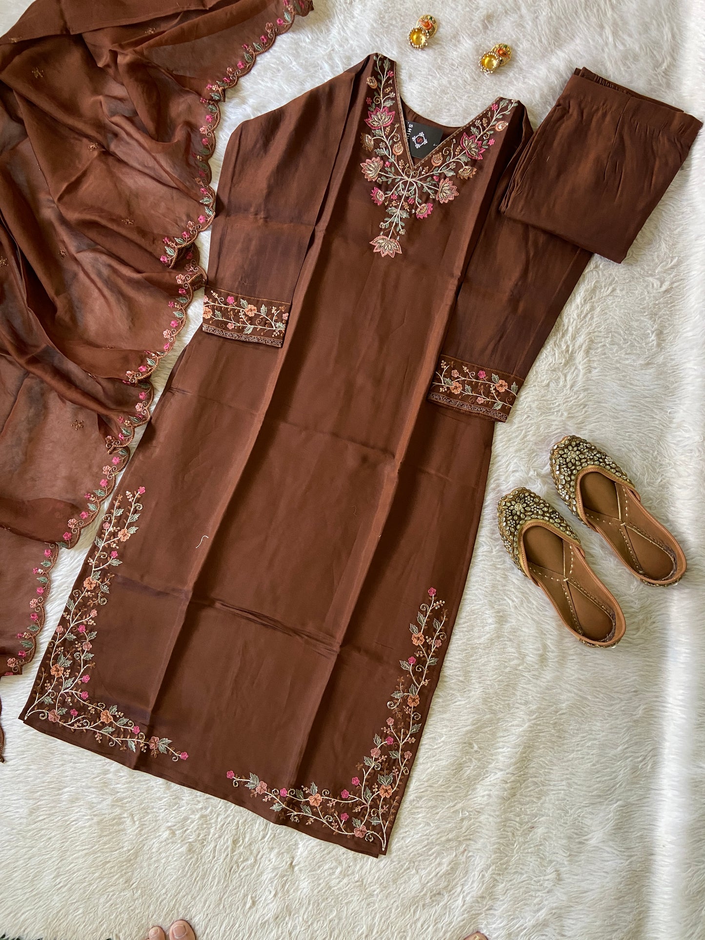 Brown embroidered outfit with matching shoes on a light background