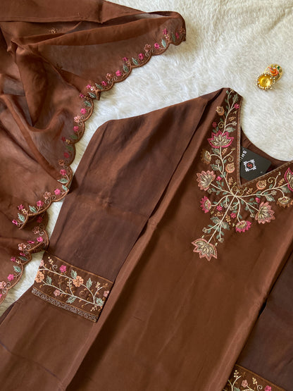 Brown fabric with intricate floral embroidery on a white surface