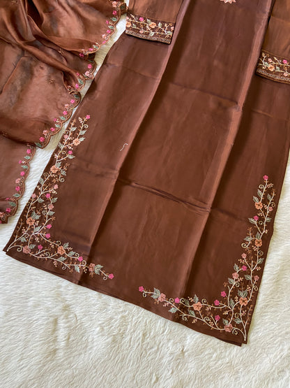 Brown fabric with floral embroidery on a white surface