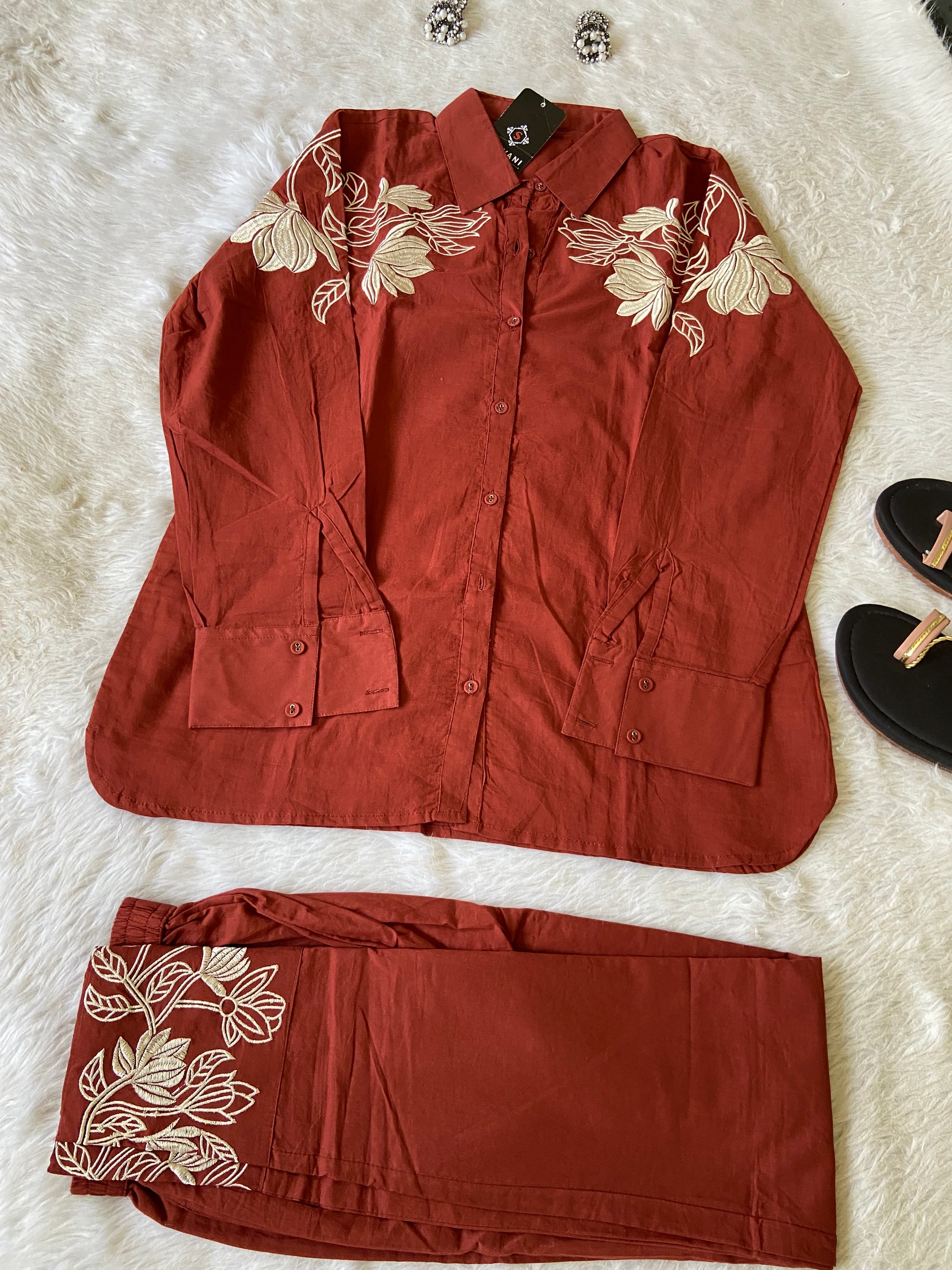 Red outfit with floral embroidery on a white surface